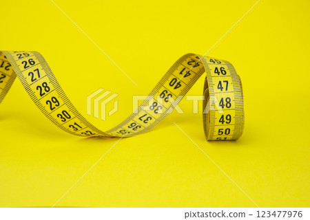 Spiral tape measure colorful background with copyspace 123477976