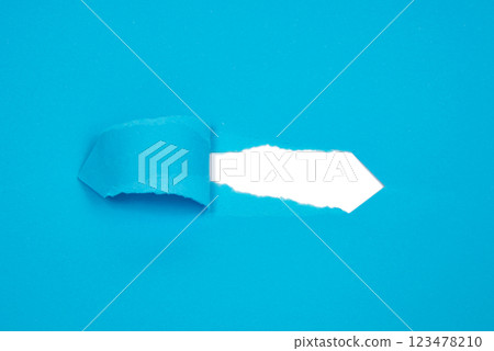 Hole in paper blue background torn damaged for design 123478210