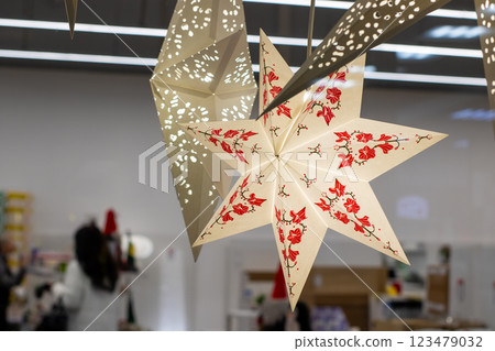 A white star with vibrant red flowers hangs beautifully from the ceiling 123479032