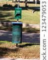 Dog waste trash can along park walkway  123479053