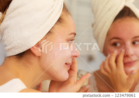 Woman applying mask cream on face in bathroom 123479061