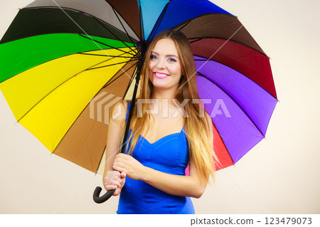 Woman in summer dress holds colorful umbrella Woman in summer dress holds colorful umbrella 123479073