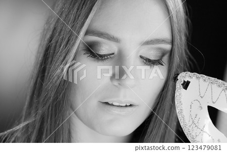 Woman holding carnival mask closeup Woman holding carnival mask closeup 123479081