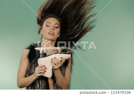 Woman with windblown hair holding ice skate 123479106