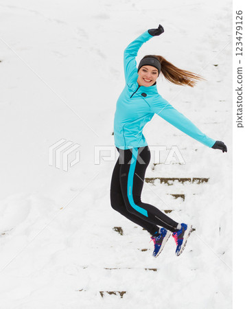 Young girl jumping on the snow. 123479126