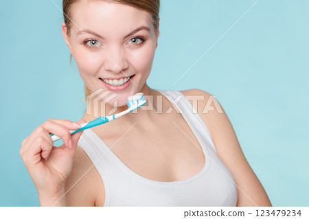 woman holds toothbrush with toothpaste cleaning teeth 123479234