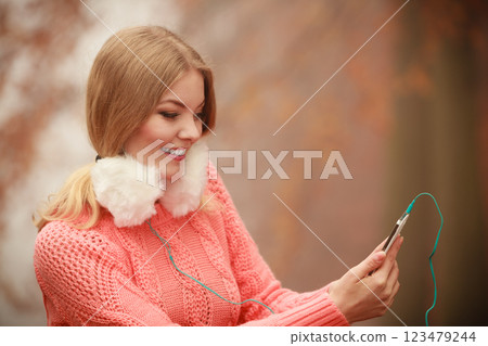 girl listening to music in autumn park 123479244