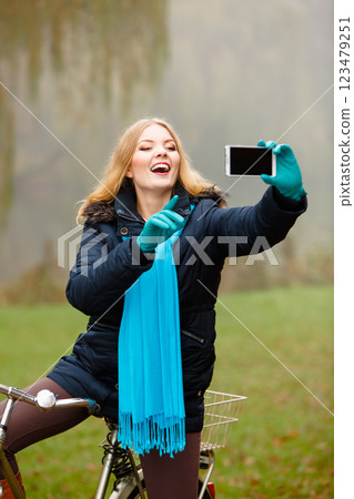 girl taking self picture with phone outdoors 123479251