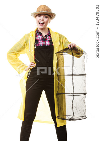 Happy woman holding empty fishing keepnet Happy woman holding empty fishing keepnet 123479303