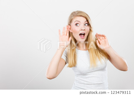 Woman putting hand ear to hear better 123479311