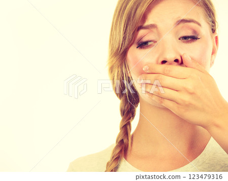 Sad woman covering mouth with hand Sad woman covering mouth with hand 123479316