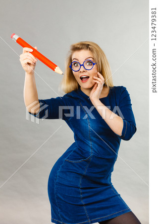 Joyful woman holds big pencil in hand 123479381