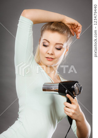 Woman drying armpit with hair dryer Woman drying armpit with hair dryer 123479440