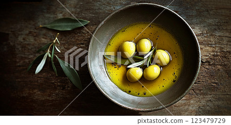 Bowl of fresh olive oil and olive branches on rustic wooden  background 123479729