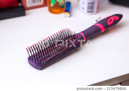 A purple hairbrush with pink bristles and an 8 on the handle 123479808