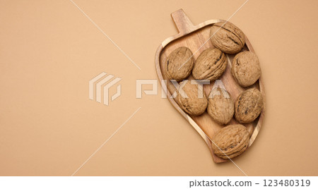 Walnut fruits on a brown background, close up Walnut fruits on a brown background, close up 123480319