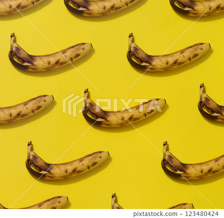 Rotten banana with shadow on yellow background, pattern Rotten banana with shadow on yellow background, pattern 123480424