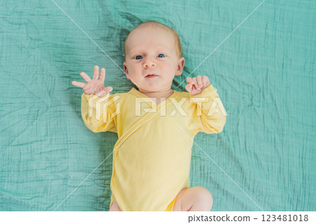 A newborn baby rests peacefully on a soft muslin swaddle, feeling comforted and secure. A tender moment of early childhood, warmth, and tranquility, symbolizing gentle care and a nurturing environment 123481018