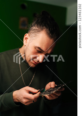 Vertical portrait of computer technician carefully cleaning motherboard components with small brush, focusing on precision and hardware maintenance, close-up. Concept of service and cleaning computer. Vertical portrait of computer technician carefully cleaning motherboard components with small brush, focusing on precision and hardware maintenance, close-up. Concept of service and cleaning computer. 123481102