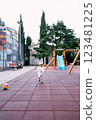 Little girl in a tracksuit runs on the playground. High quality photo 123481225