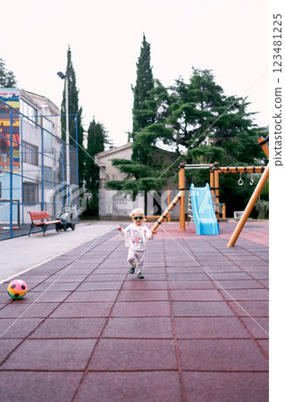 Little girl in a tracksuit runs on the playground. High quality photo Little girl in a tracksuit runs on the playground. High quality photo 123481225