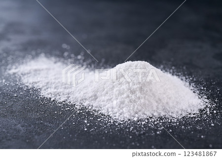 Pile of salt on a black stone table, selective focus. 123481867