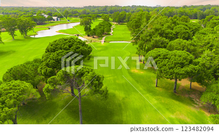 Aerial view of a golf course with a winding river, lush greenery, and manicured fairways 123482094