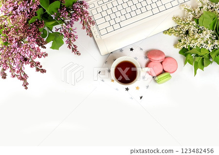 Modern woman's desktop, home office, a cup of flower tea and cookies on a light table with lilac flowers. Healthy breakfast with ingredients, healthy lifestyle concept, flat lay Modern woman's desktop, home office, a cup of flower tea and cookies on a light table with lilac flowers. Healthy breakfast with ingredients, healthy lifestyle concept, flat lay 123482456