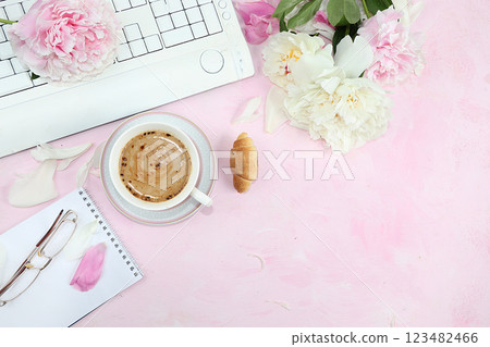 Work desk of a modern woman, home office. Computer, daisies and a cup of coffee on a pink old table. lifestyle concept, flat lay, place for text 123482466