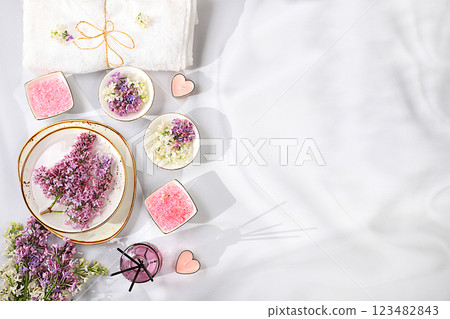Spa and wellness composition with aromatic pink salt, lilac water and lilac flowers, aromatherapy and skin care, lifestyle and organic cosmetics concept, salon invitation and advertisement, selective Spa and wellness composition with aromatic pink salt, lilac water and lilac flowers, aromatherapy and skin care, lifestyle and organic cosmetics concept, salon invitation and advertisement, selective 123482843