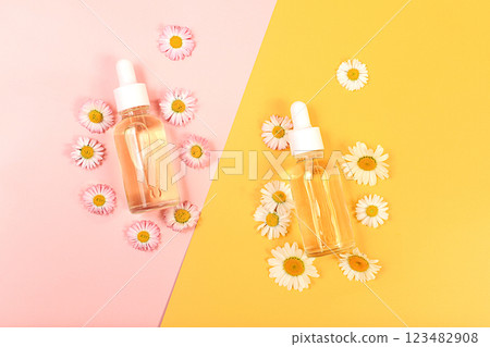 Bottles with lotion with chamomile extracts and flowers on a light background, the concept of natural organic cosmetics, advertising for spa and store, top view.. Bottles with lotion with chamomile extracts and flowers on a light background, the concept of natural organic cosmetics, advertising for spa and store, top view.. 123482908