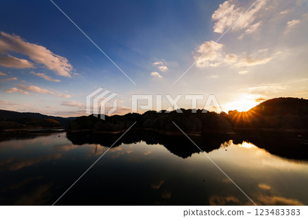The temperature is rising and it feels like spring at Nunome Dam. The sky and lake are dyed golden from before sunset to the night sky. 123483383