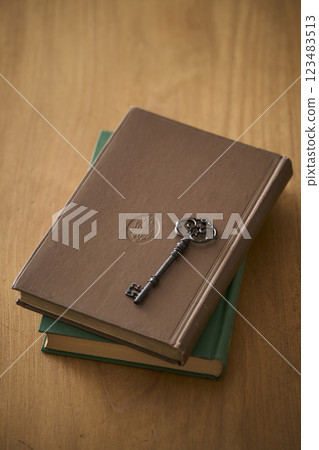 Antique key on top of an old book Antique key on top of an old book 123483513