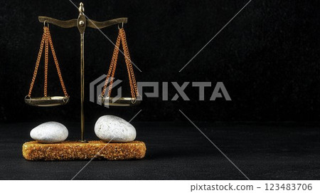 Balanced Scales of Justice with Stones on Dark Background Balanced Scales of Justice with Stones on Dark Background 123483706