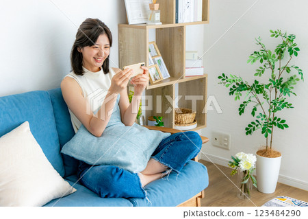 A smiling woman looking at a smartphone A smiling woman looking at a smartphone 123484290