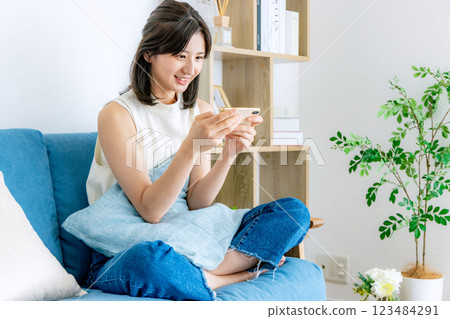 A smiling woman looking at a smartphone A smiling woman looking at a smartphone 123484291