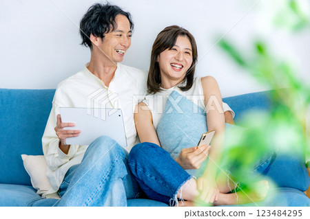 Couple looking at tablet and smartphone 123484295