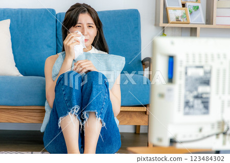 A woman who cries watching TV 123484302