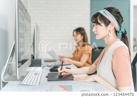 A woman who works as a photo editor, image editor, photo processor, retoucher, and graphic designer A woman who works as a photo editor, image editor, photo processor, retoucher, and graphic designer 123484470