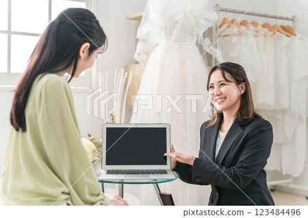 一位女士與婚禮策劃師開會選擇禮服 123484496
