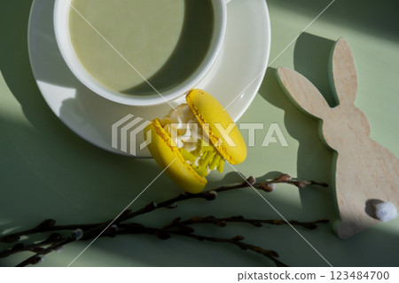 Green latte matcha with yellow macaron dessert and EASTER sustainable decoration. Concept of holiday breakfast morning tea drink. Cozy minimalist superfood vibrant colors healthy eating. Organic Green latte matcha with yellow macaron dessert and EASTER sustainable decoration. Concept of holiday breakfast morning tea drink. Cozy minimalist superfood vibrant colors healthy eating. Organic 123484700