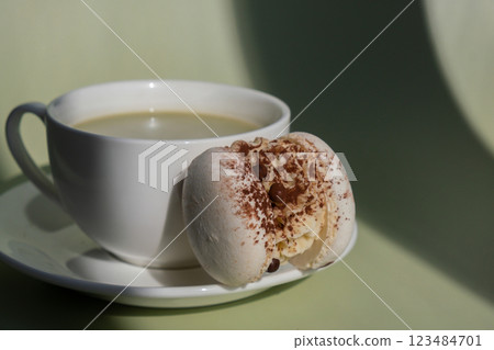 Green latte matcha with white cacao macaron dessert on pastel background with creative deep shadows. Concept of holiday breakfast morning tea drink. Cozy minimalist superfood vibrant colors healthy Green latte matcha with white cacao macaron dessert on pastel background with creative deep shadows. Concept of holiday breakfast morning tea drink. Cozy minimalist superfood vibrant colors healthy 123484701