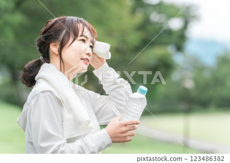 一名亞洲女性在運動/步行時補水後休息的概況 一名亞洲女性在運動/步行時補水後休息的概況 123486382