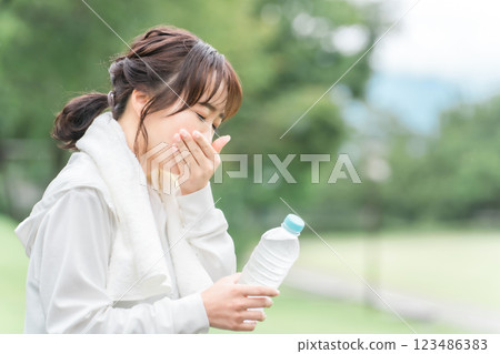 亞洲女性在運動休息期間補充水分 亞洲女性在運動休息期間補充水分 123486383