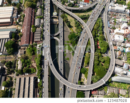 Top view of highway intersections with a cityscape in the background and urban greenery. Bangkok, Thailand. Top view of highway intersections with a cityscape in the background and urban greenery. Bangkok, Thailand. 123487028