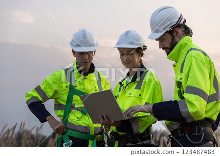 Engineer wearing safety uniform using tablet discussed plan about renewable energy at station energy power wind turbine. technology protect environment reduce global warming problems. 123487483