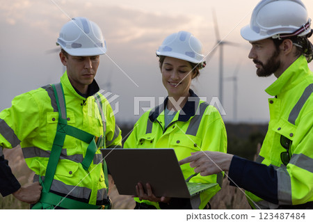 Engineer wearing safety uniform using tablet discussed plan about renewable energy at station energy power wind turbine. technology protect environment reduce global warming problems. 123487484