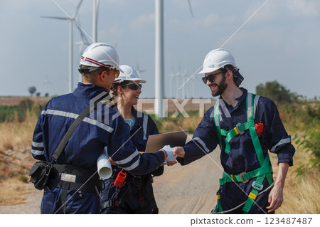 Successful teamwork engineer wind turbine worker safety uniform survey operational planning windmill field clean energy. Alternative technology protect environment reduce global warming problems. 123487487