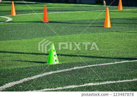 artificial green grass soccer field with orange training cones 123487878