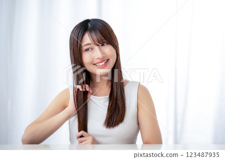 Young woman combing her hair with her hands 123487935